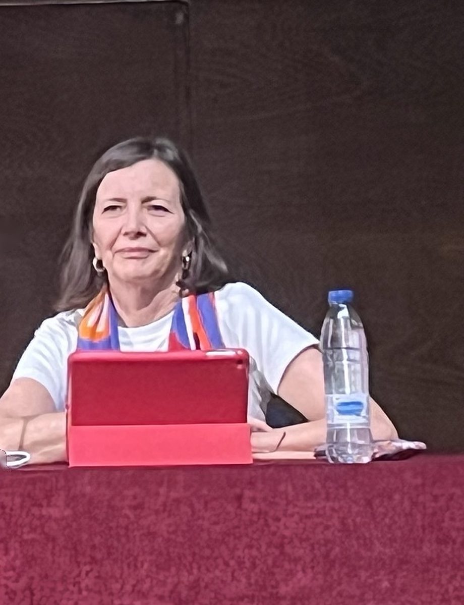 Carolina Barrios en la mesa de unas jornadas, escuchando